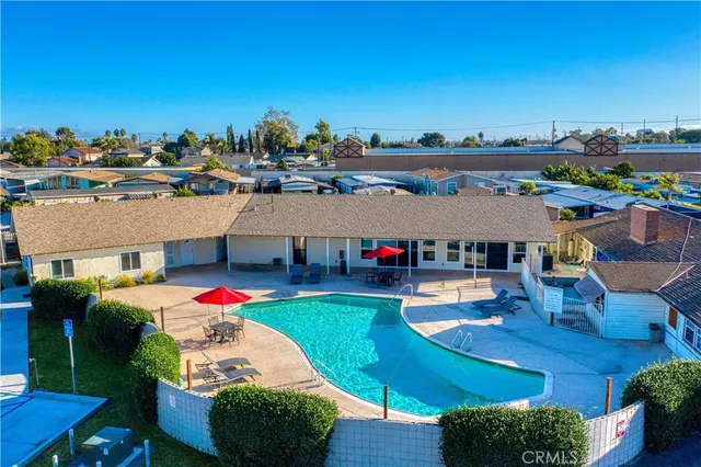 a view of a swimming pool with a patio and dining table