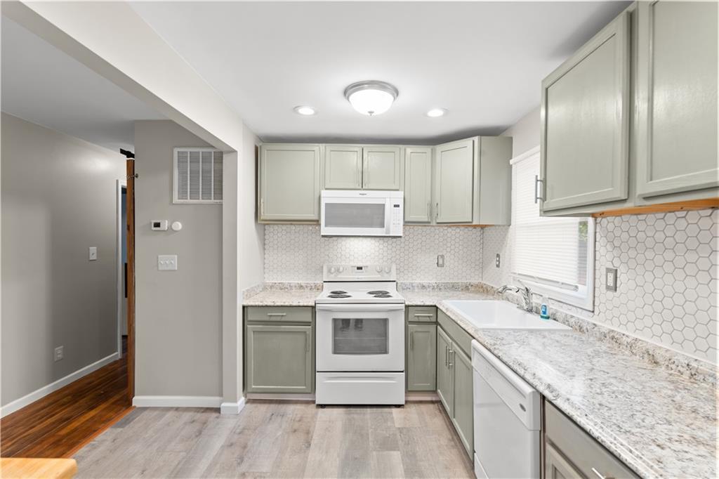 2161 Rochelle Way Southwest Atlanta, GA 30349 - Photo 15 of 15 a kitchen with a stove sink and cabinets