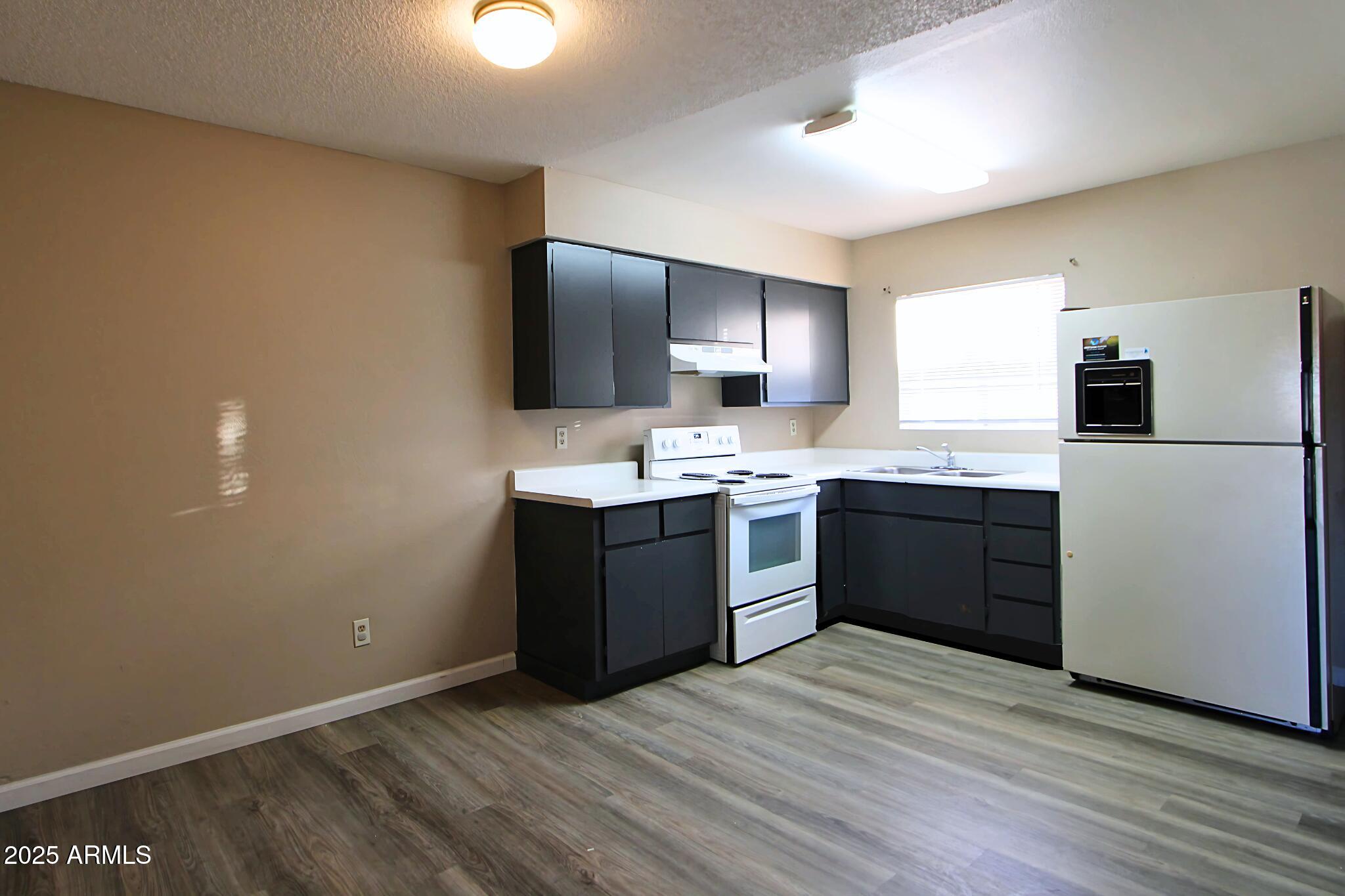 6446 East Alder Avenue, Unit 102 Mesa, AZ 85206 - Photo 1 of 9 a kitchen with stainless steel appliances kitchen island granite countertop a stove a sink and a refrigerator