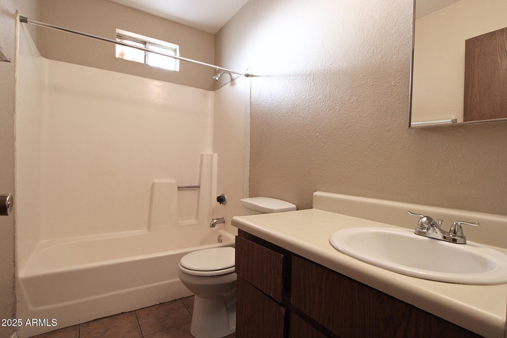 6446 East Alder Avenue, Unit 102 Mesa, AZ 85206 - Photo 6 of 9 a bathroom with a sink a toilet and shower