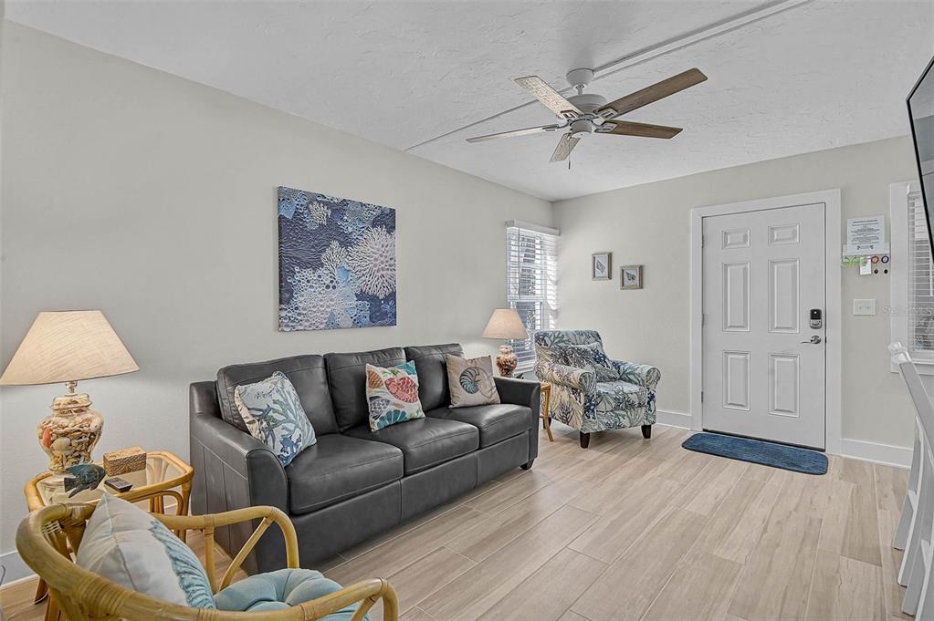 5950 Midnight Pass Road, Unit 101 Sarasota, FL 34242 - Photo 11 of 17 a living room with furniture and a wooden floor