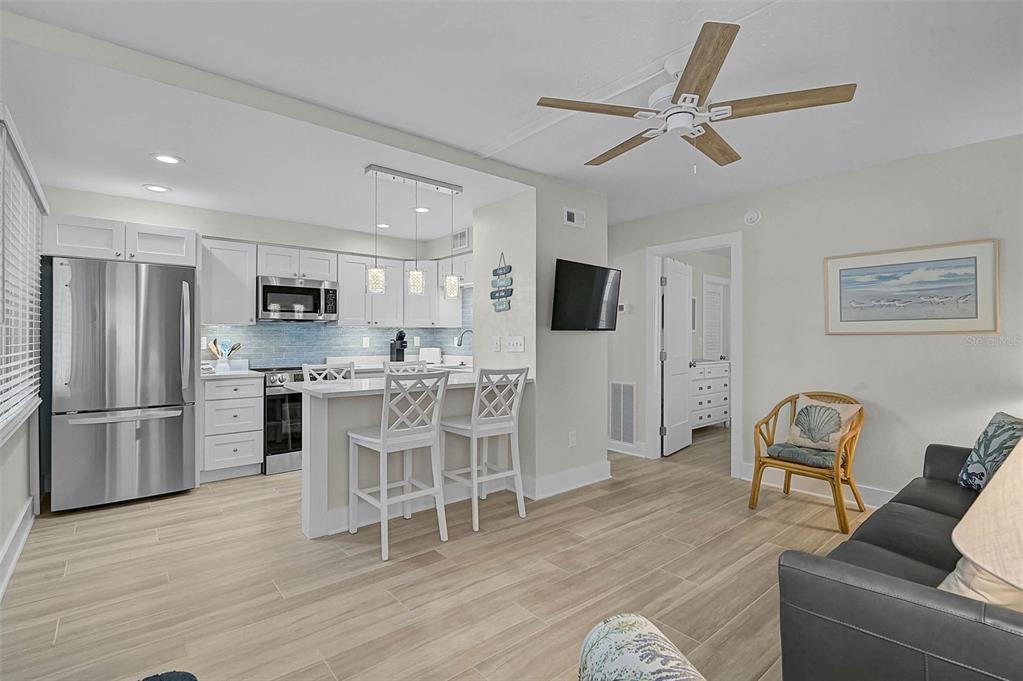 5950 Midnight Pass Road, Unit 101 Sarasota, FL 34242 - Photo 13 of 17 a living room with furniture a refrigerator and kitchen view