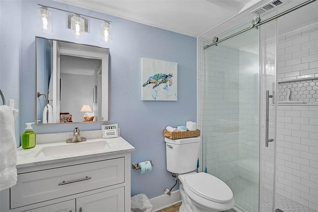 5950 Midnight Pass Road, Unit 101 Sarasota, FL 34242 - Photo 16 of 17 a bathroom with a sink a toilet and shower