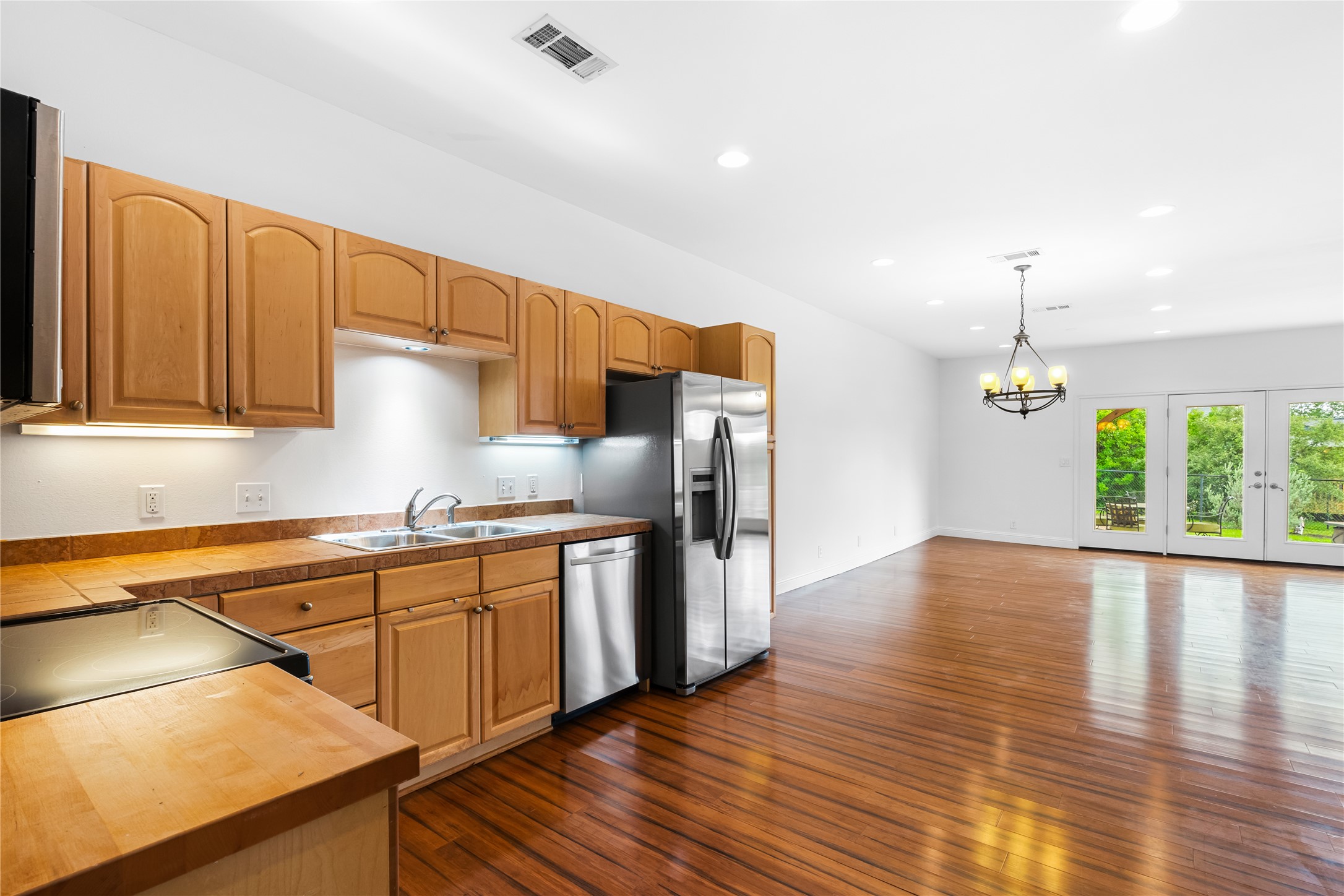 5500 Sunset Ridge, Unit A & B Austin, TX 78735 - Photo 26 of 32 a kitchen with stainless steel appliances granite countertop a refrigerator a sink dishwasher a stove and white countertops with wooden floor
