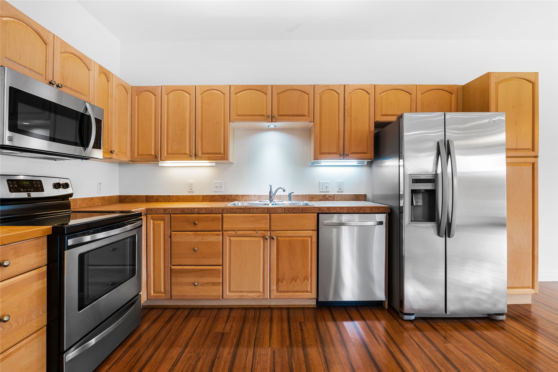 5500 Sunset Ridge, Unit A & B Austin, TX 78735 - Photo 27 of 32 a kitchen with stainless steel appliances granite countertop a refrigerator a stove and a microwave oven with wooden floor