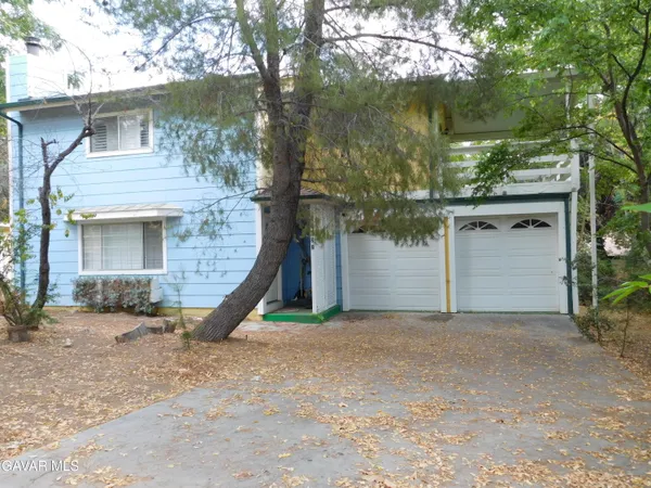 a view of a house with a yard and tree