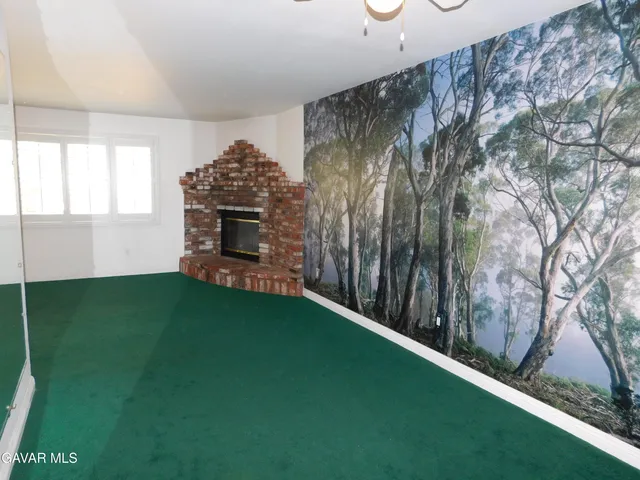 a living room with a fireplace furniture and a large window