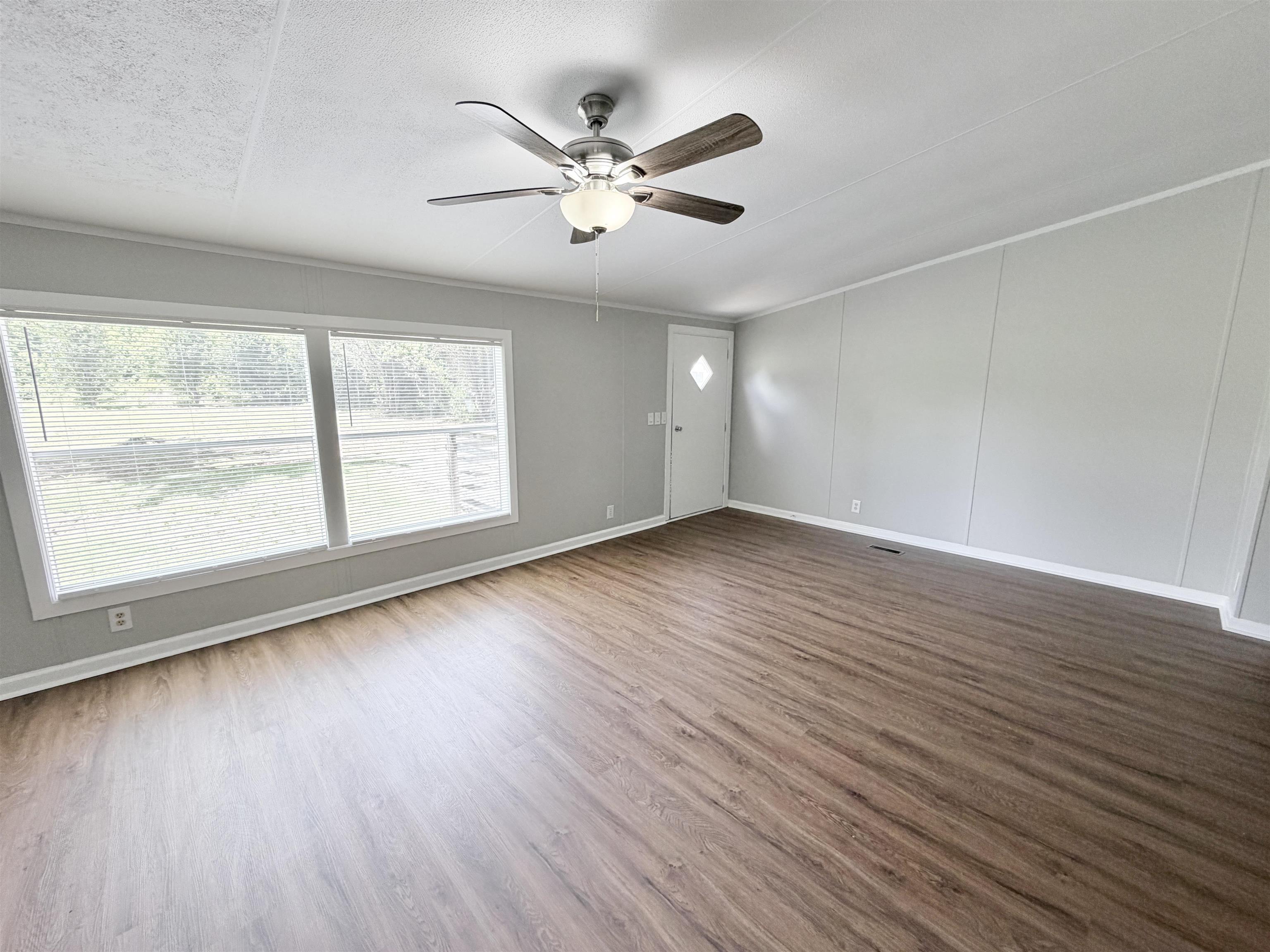 1655 Fayne Road Brighton, TN 38011 - Photo 9 of 28 Spacious interior featuring wood-finish flooring, light grey walls, and a ceiling fan with integrated lighting