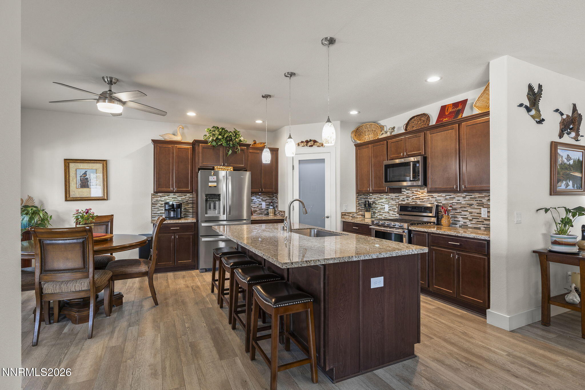 404 Chianti Way Dayton, NV 89403 - Photo 15 of 42 a kitchen with stainless steel appliances kitchen island granite countertop a table chairs and a refrigerator