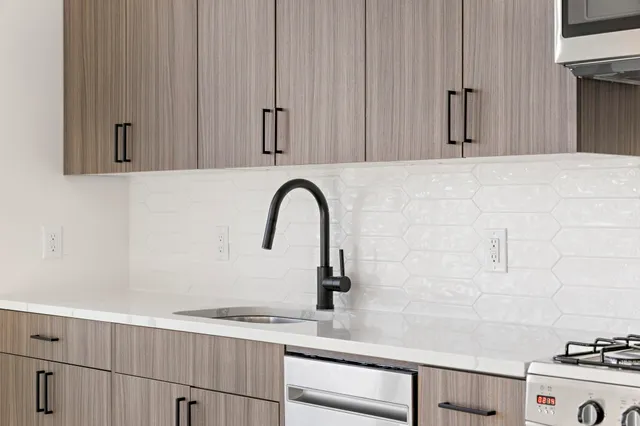 a close view of a faucet a sink and a stove in the kitchen