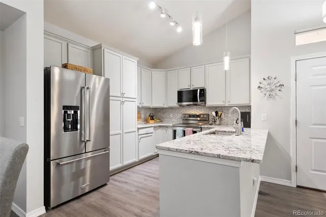 a kitchen with stainless steel appliances granite countertop a refrigerator stove microwave and sink