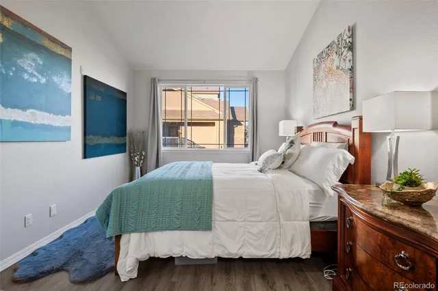 a bedroom with a bed and a potted plant on dresser