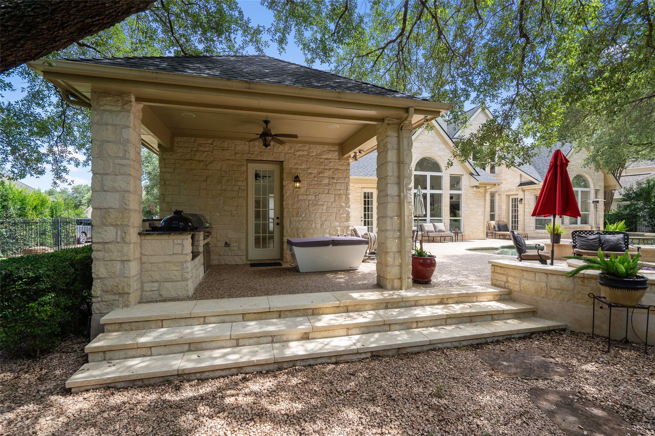4313 Rio Robles Drive Austin, TX 78746 - Photo 33 of 40 An inviting outdoor oasis features a built-in barbecue and a relaxing spa, all under a shaded patio.