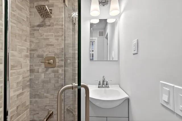 a bathroom with a granite countertop sink a toilet and mirror