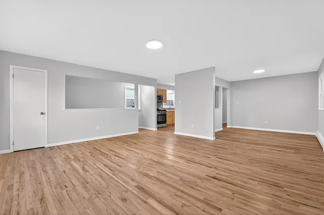 a view of empty room with wooden floor