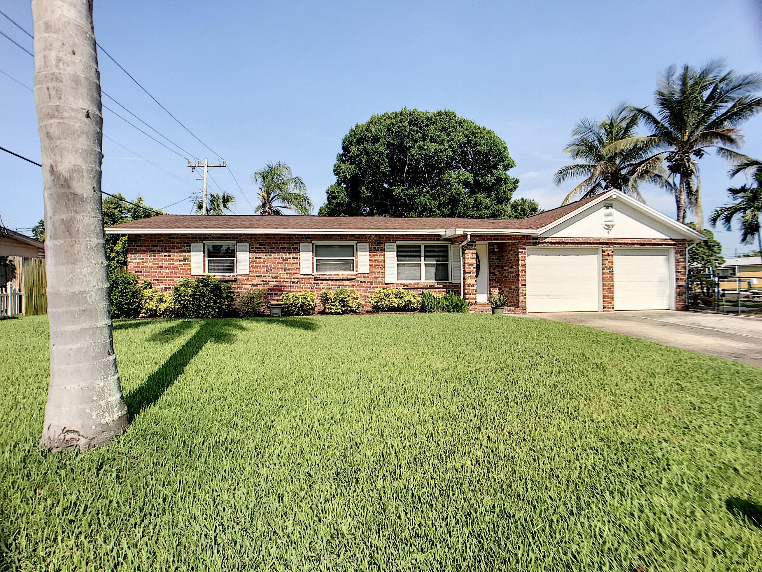 327 3rd Street Merritt Island, FL 32953 - Photo 2 of 26 a front view of a house with garden