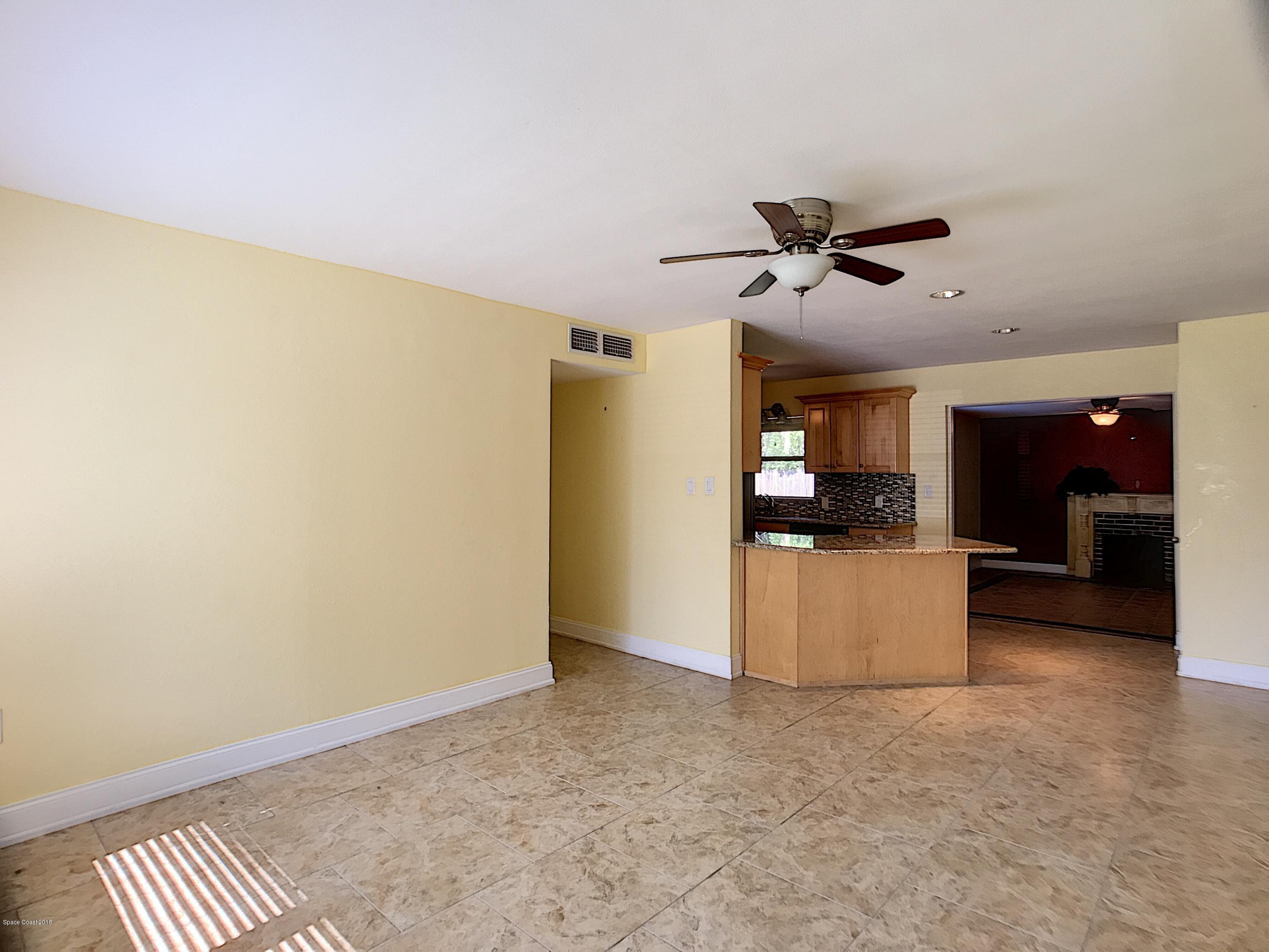 327 3rd Street Merritt Island, FL 32953 - Photo 12 of 26 a view of a kitchen with a sink and a refrigerator