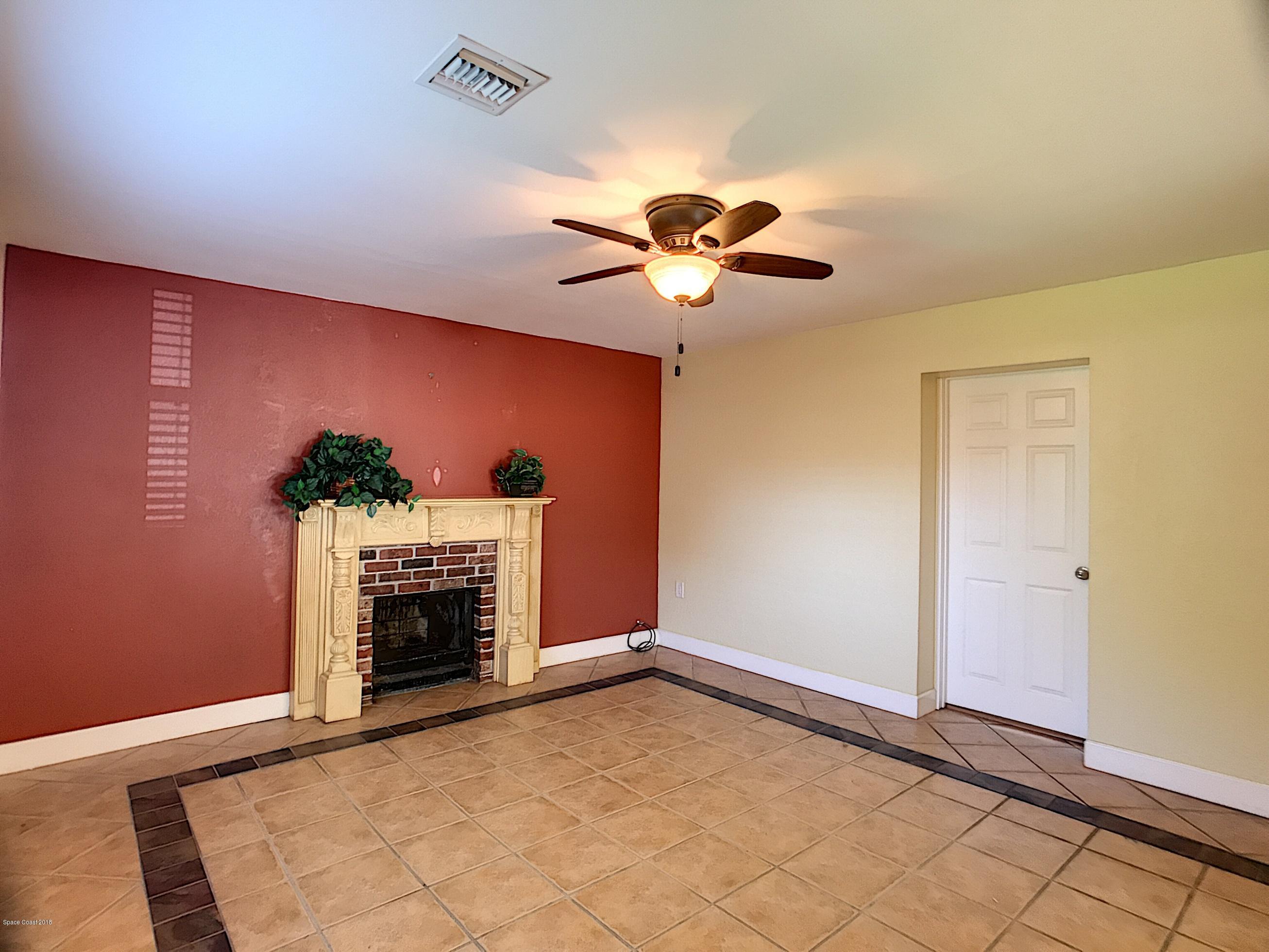 327 3rd Street Merritt Island, FL 32953 - Photo 15 of 26 a view of an empty room with a fireplace and a potted plant