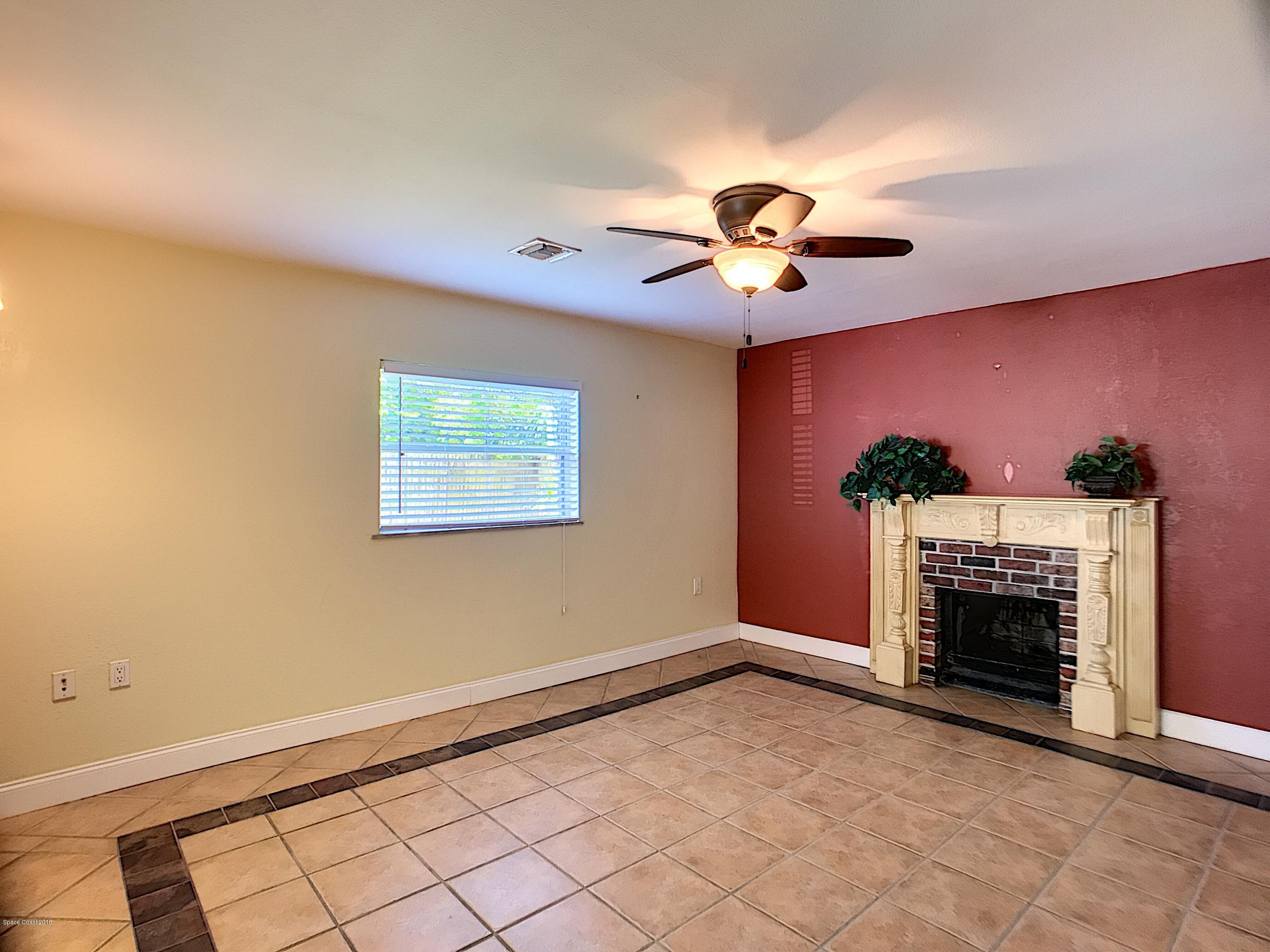 327 3rd Street Merritt Island, FL 32953 - Photo 16 of 26 a view of a livingroom with a fireplace and a chandelier