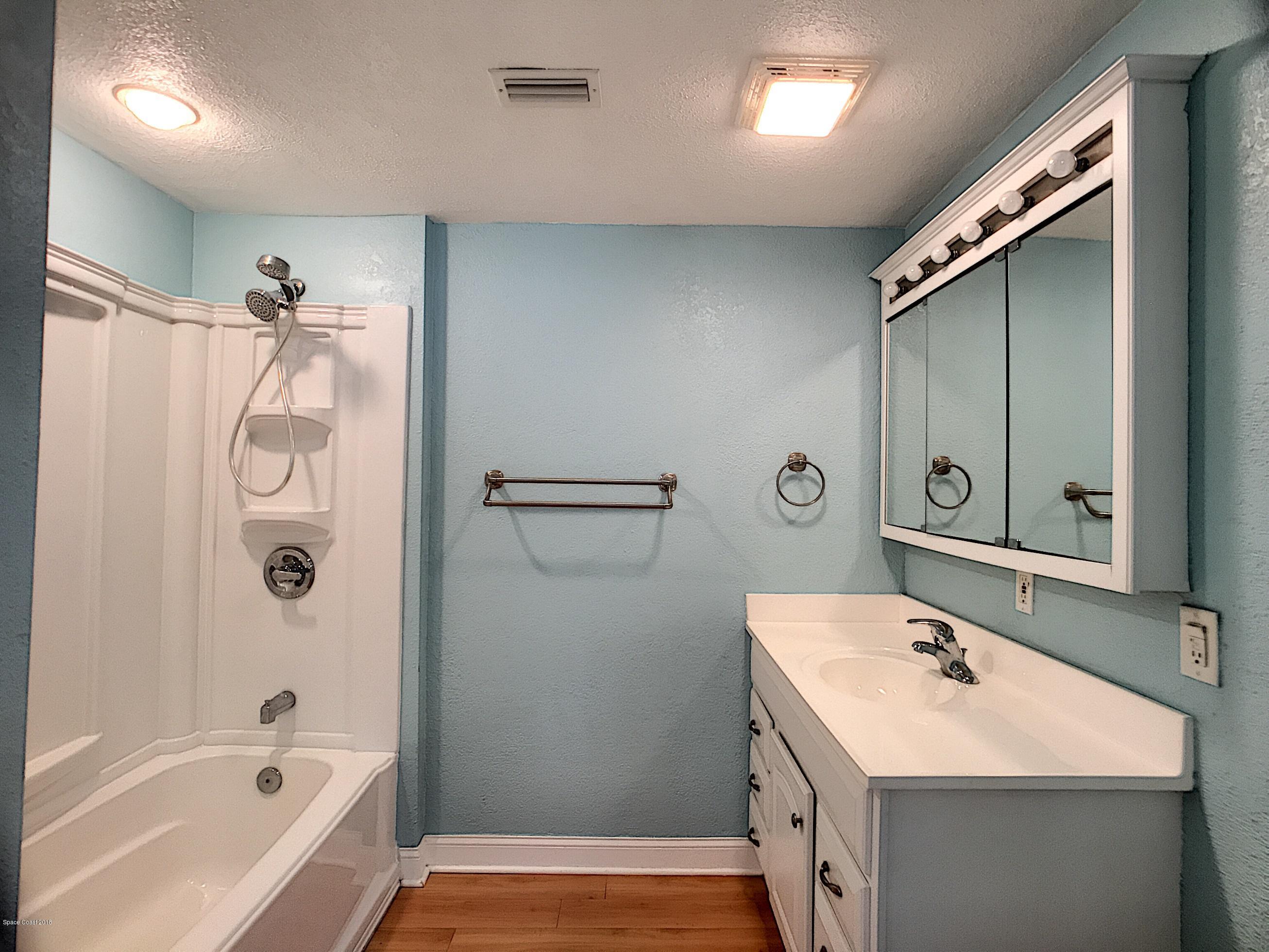 327 3rd Street Merritt Island, FL 32953 - Photo 17 of 26 a bathroom with a tub sink and mirror