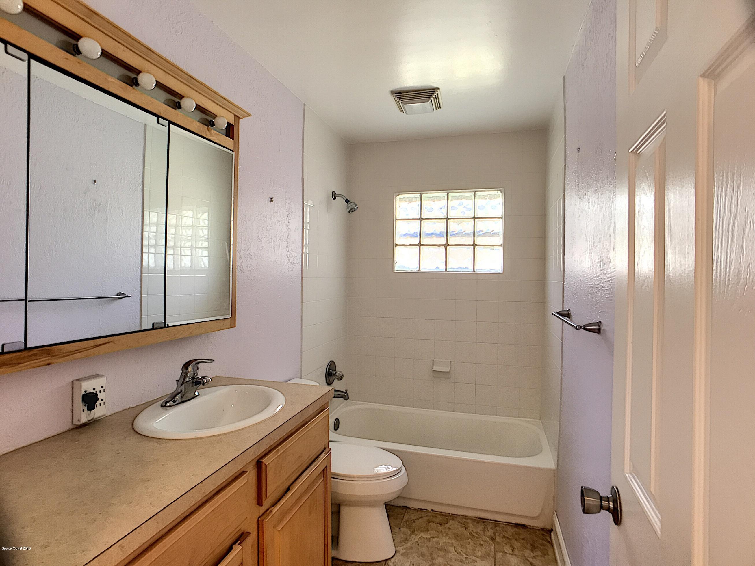 327 3rd Street Merritt Island, FL 32953 - Photo 18 of 26 a bathroom with a sink and a mirror