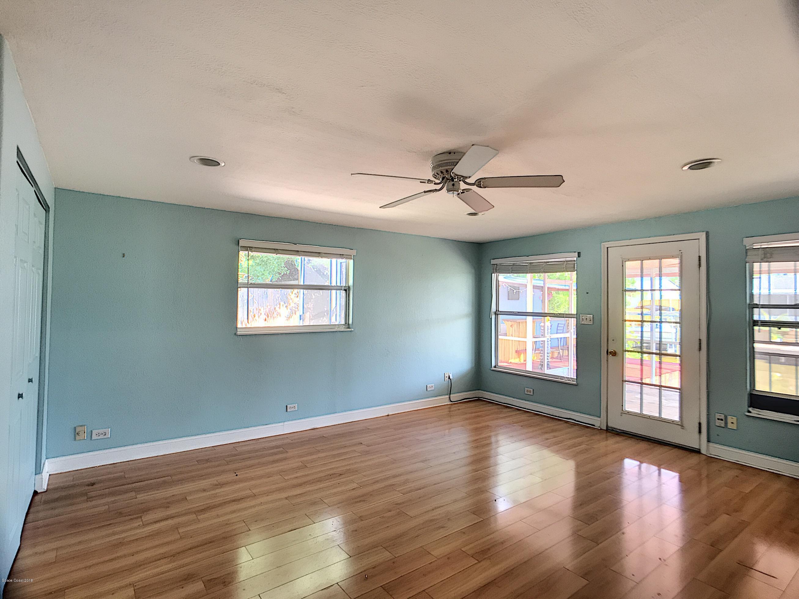327 3rd Street Merritt Island, FL 32953 - Photo 5 of 26 a view of an empty room with a window and wooden floor