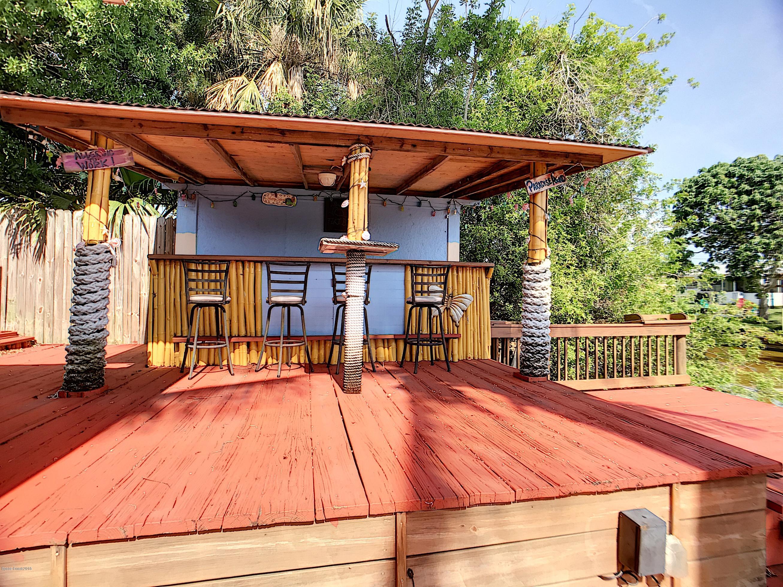 327 3rd Street Merritt Island, FL 32953 - Photo 7 of 26 a patio with wooden floor a yard a table and chairs