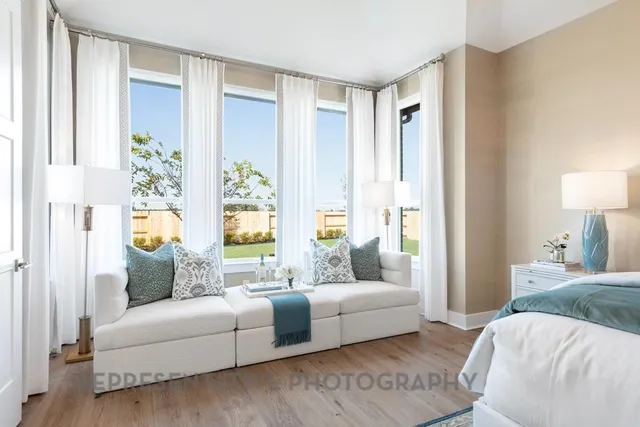 a bedroom with furniture and a large window