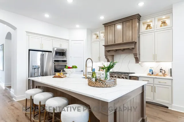 a kitchen with stainless steel appliances granite countertop a kitchen island a stove a table and chairs
