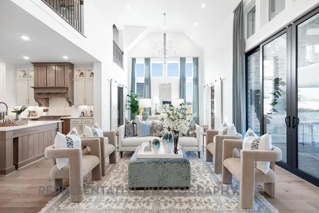 a living room with furniture a table and large windows
