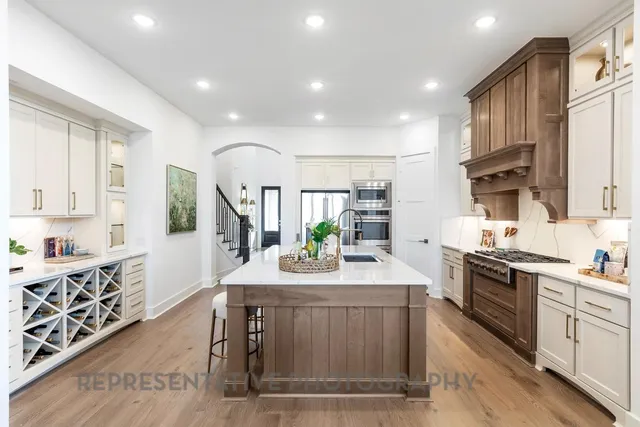 a kitchen with stainless steel appliances kitchen island granite countertop a stove a sink and a refrigerator
