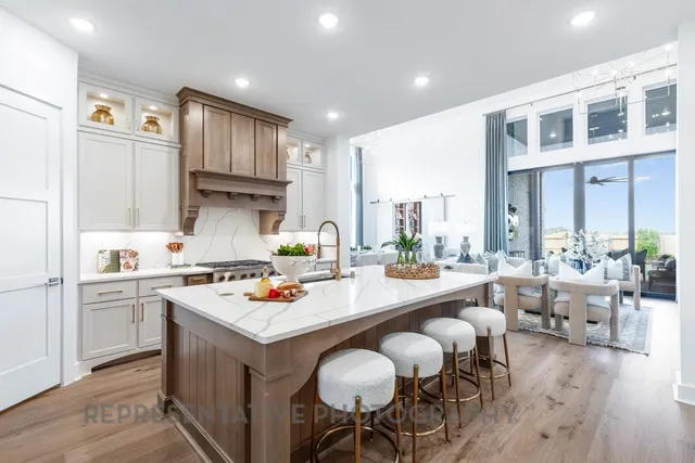 a open kitchen with stainless steel appliances granite countertop a stove and white cabinets