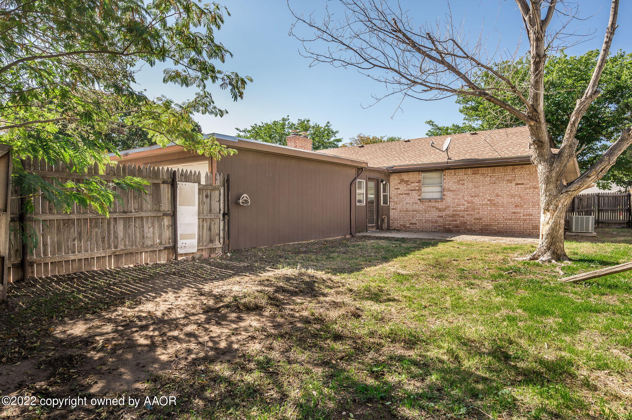 3405 Thurman Street Amarillo, TX 79109 - Photo 18 of 19 a backyard of a house with large trees and brick walls