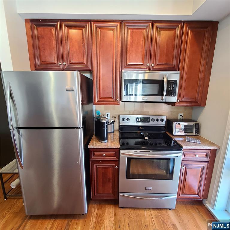 182 Anderson Avenue, Unit 3A Fairview, NJ 07022 - Photo 12 of 19 a kitchen with granite countertop a refrigerator stove and microwave