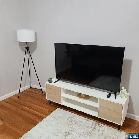 a living room with a flat screen tv and a wooden floor