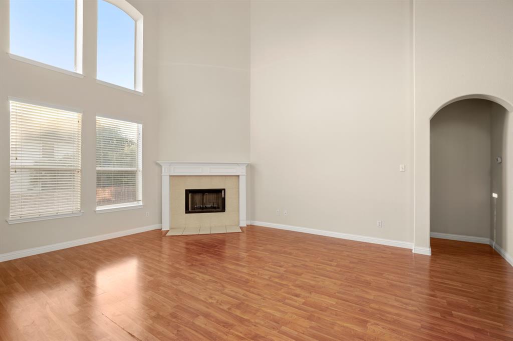 10105 Wind Cave Trail Austin, TX 78747 - Photo 2 of 23 Living area featuring a fireplace with a white mantel, tile surround, and a dark firebox