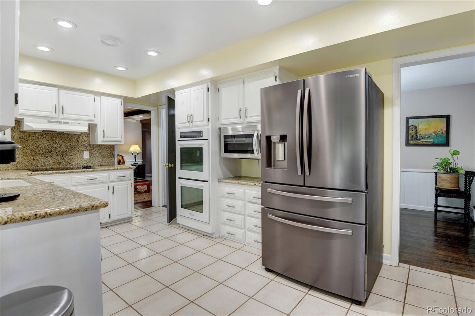 3515 Otis Street Wheat Ridge, CO 80033 - Photo 13 of 37 a kitchen with stainless steel appliances granite countertop a refrigerator sink and stove