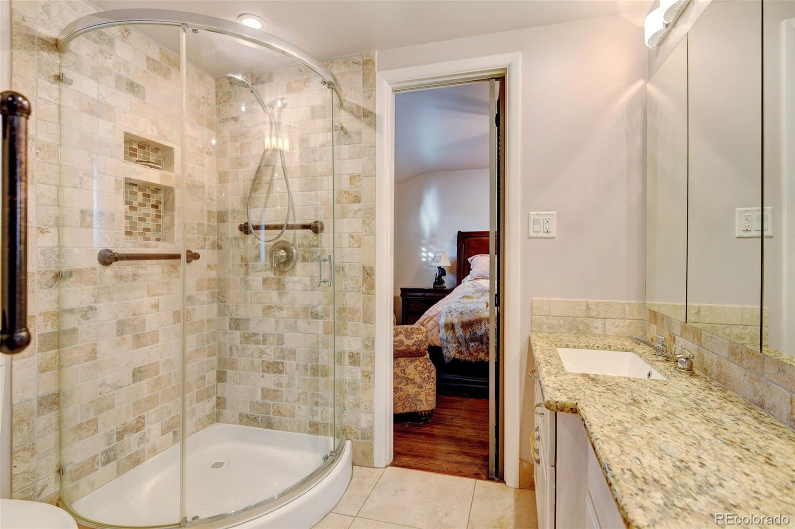 3515 Otis Street Wheat Ridge, CO 80033 - Photo 17 of 37 a spacious bathroom with a granite countertop tub sink and shower