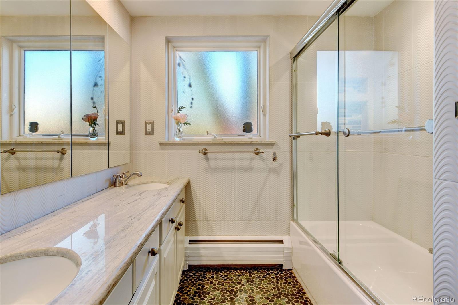3515 Otis Street Wheat Ridge, CO 80033 - Photo 20 of 37 a bathroom with a granite countertop sink a mirror and a bathtub