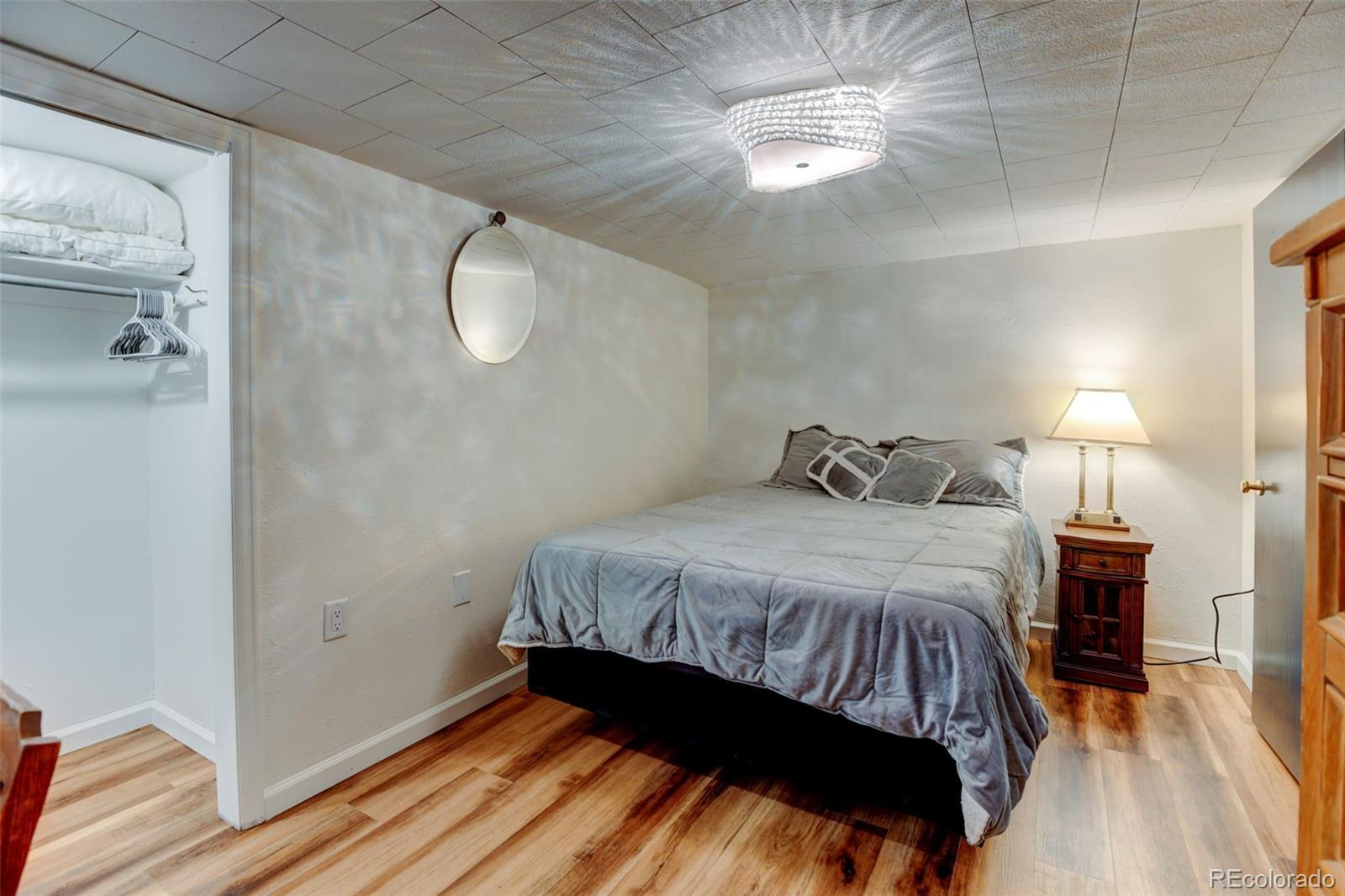 3515 Otis Street Wheat Ridge, CO 80033 - Photo 26 of 37 a bedroom with a bed and a chandelier