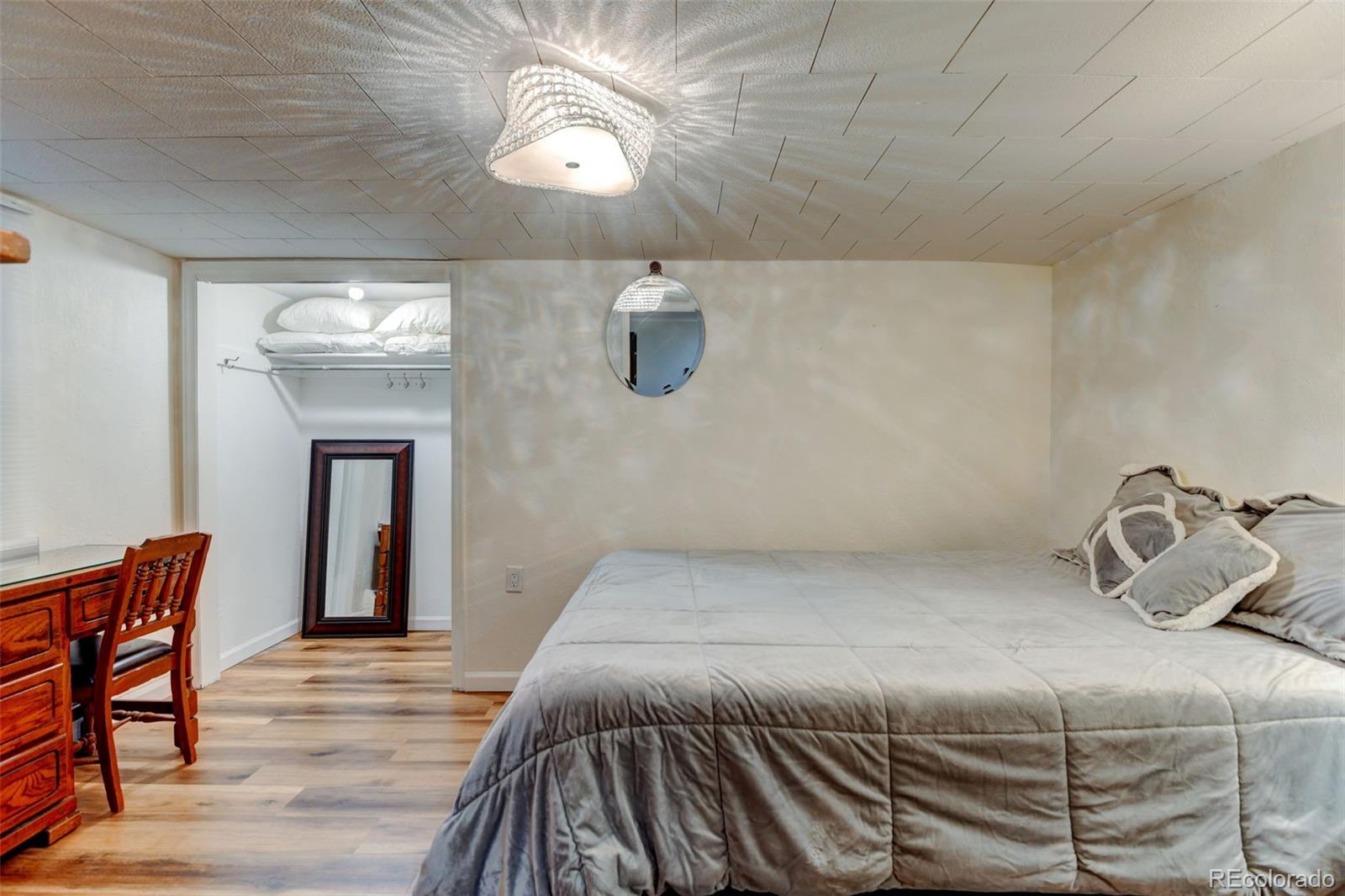 3515 Otis Street Wheat Ridge, CO 80033 - Photo 27 of 37 a bedroom with a bed and a chandelier