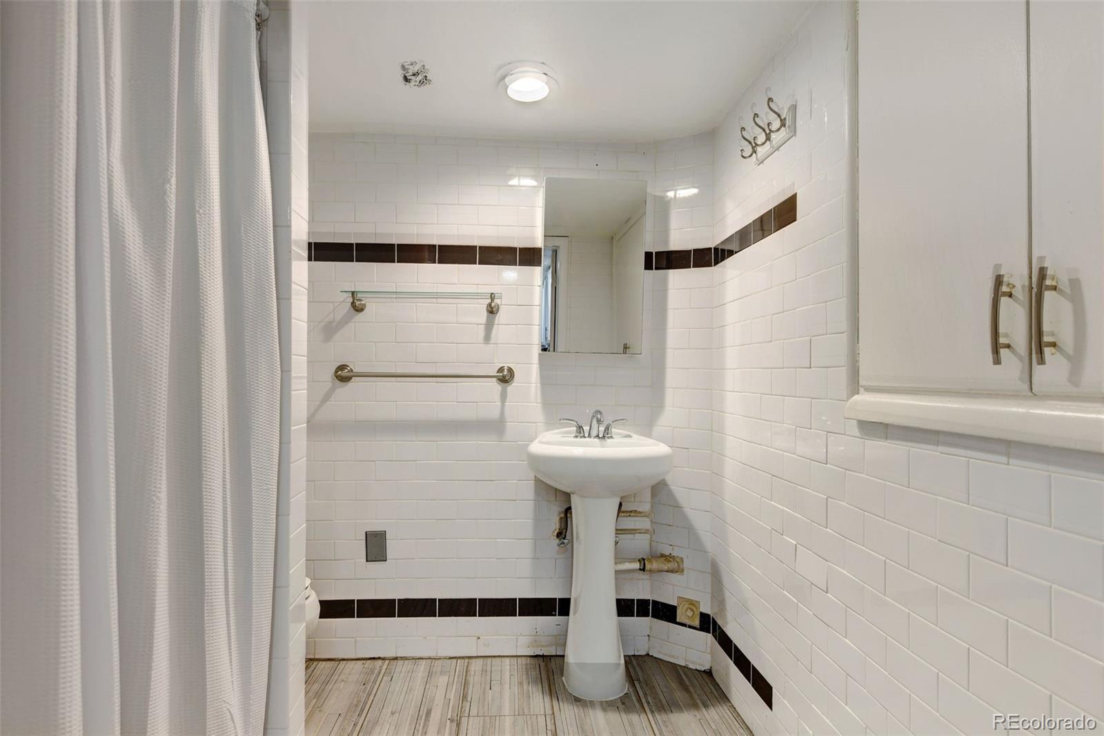 3515 Otis Street Wheat Ridge, CO 80033 - Photo 28 of 37 a bathroom with a sink a toilet and a shower