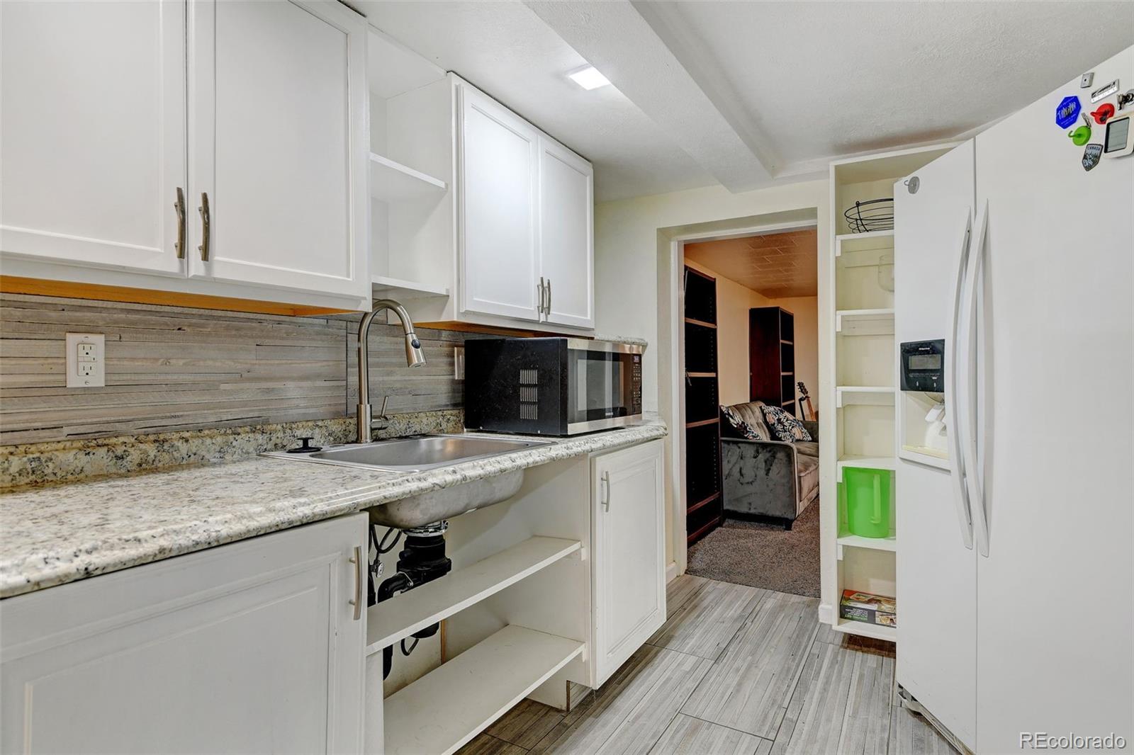 3515 Otis Street Wheat Ridge, CO 80033 - Photo 29 of 37 a kitchen with a sink appliances and cabinets