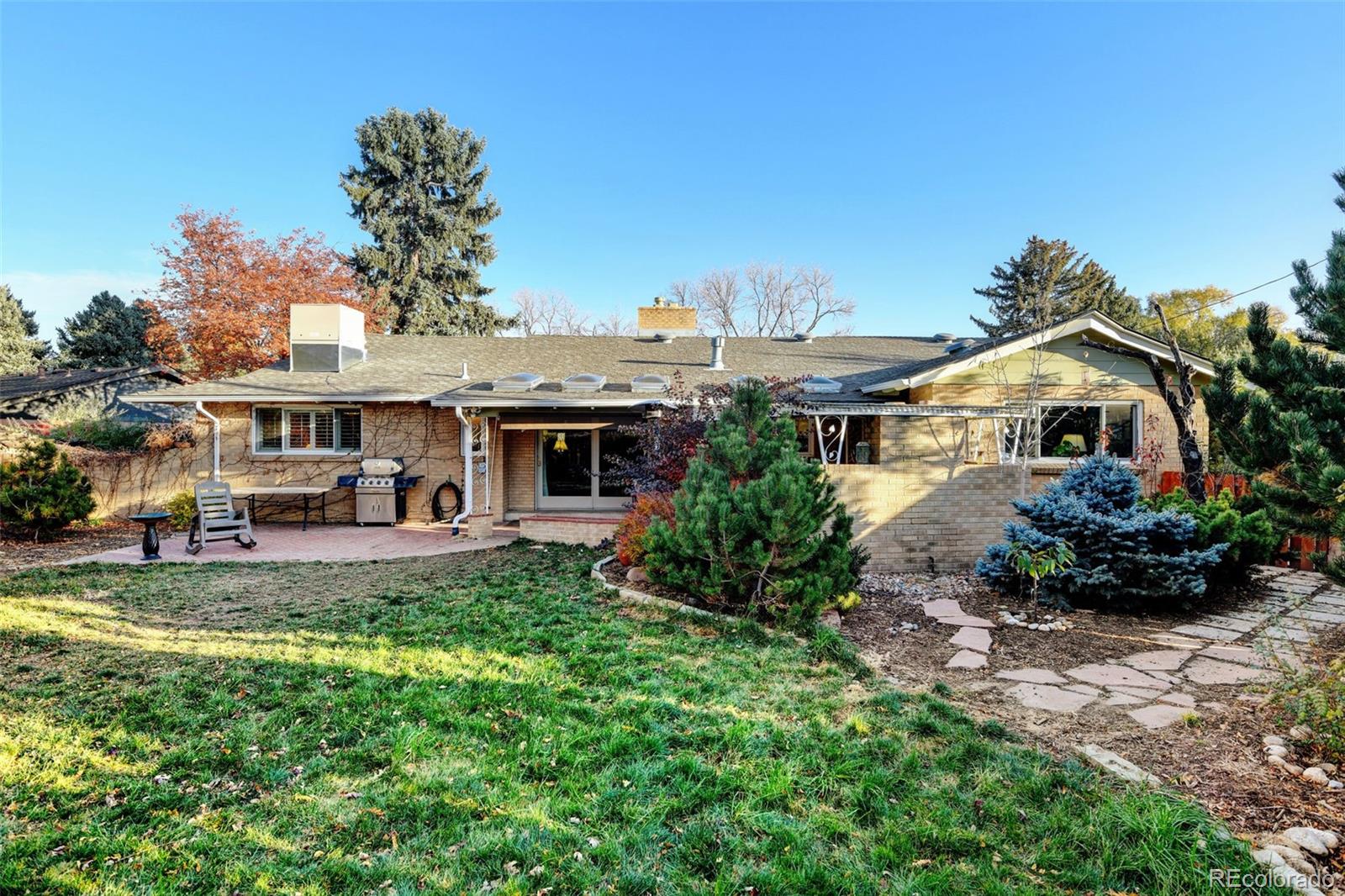 3515 Otis Street Wheat Ridge, CO 80033 - Photo 30 of 37 a view of a house with table and chairs under an umbrella
