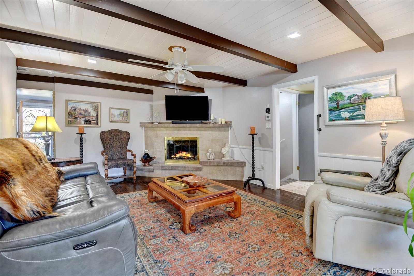3515 Otis Street Wheat Ridge, CO 80033 - Photo 8 of 37 a living room with furniture a flat screen tv and a fireplace