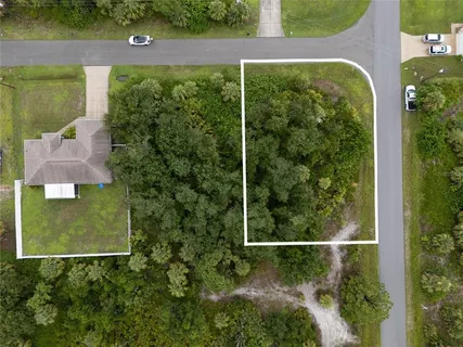 an aerial view of a residential houses with yard