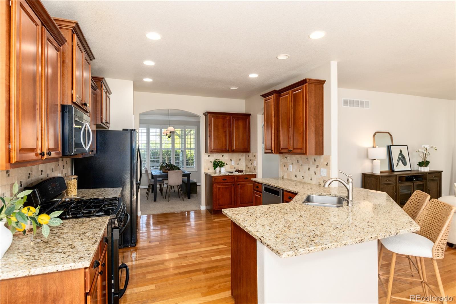 3064 Rams Horn Run Broomfield, CO 80023 - Photo 12 of 47 a kitchen with stainless steel appliances granite countertop sink stove top oven and cabinets