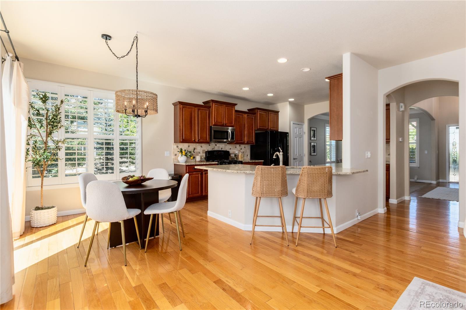 3064 Rams Horn Run Broomfield, CO 80023 - Photo 14 of 47 a view of a dining room with furniture a chandelier and wooden floor
