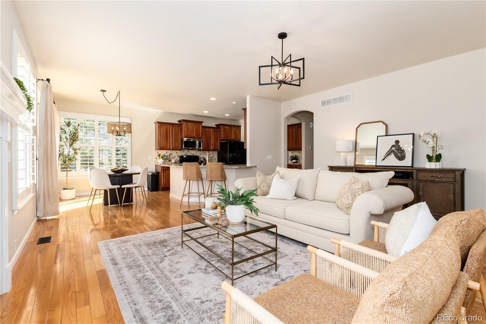 3064 Rams Horn Run Broomfield, CO 80023 - Photo 19 of 47 a living room with furniture wooden floor and a chandelier