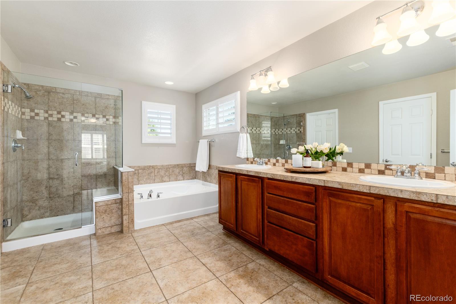 3064 Rams Horn Run Broomfield, CO 80023 - Photo 26 of 47 a spacious bathroom with a granite countertop sink a toilet a mirror and bathtub